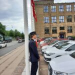En mandelig student står med ryggen op ad en flagstang på Øster Voldgade 10