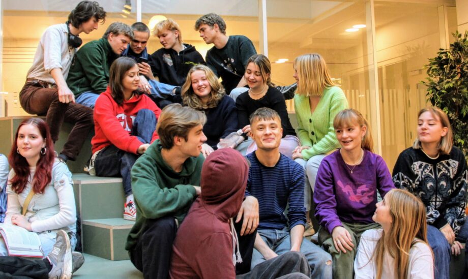 Elever snakker, sidder på trapper på biblioteket på Gefion Gymnasium