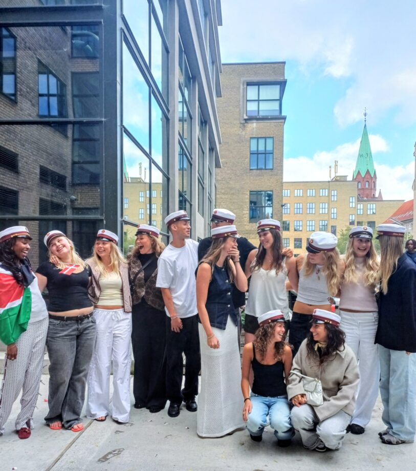 Studenter på Gefion 2025. En stor gruppe studenter med hvide huer står samme og smiler og ler.