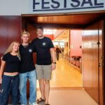 Skolestart for 1. g 2025. Tre tutorer foran Festsalen.