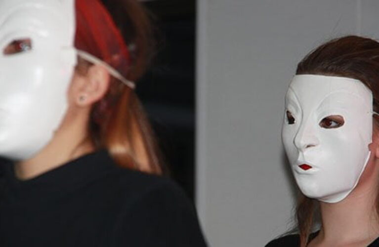 To elever med hvide masker på