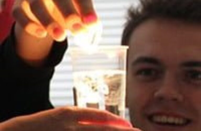 Elever i færd med at lave et forsøg i et glas