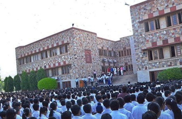 A lot of students in white shirts in front of Xavier's Senior Secondary School