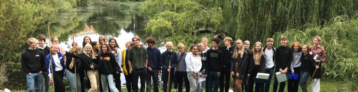 Gruppebilleder af elever der står foran å med fiskenet